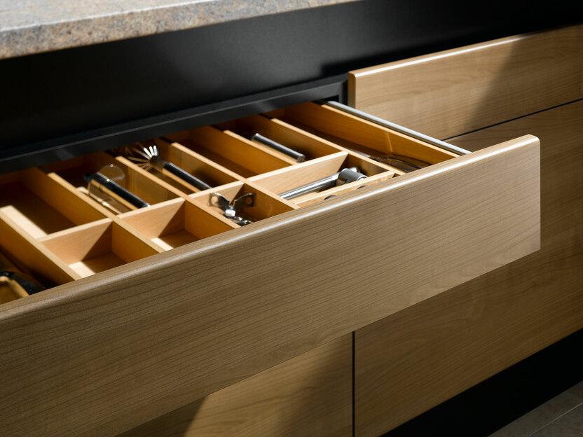 Detailaufnahme einer Besteckschublade aus Massivholz Detailaufnahme einer Besteckschublade aus hellem Massivholz