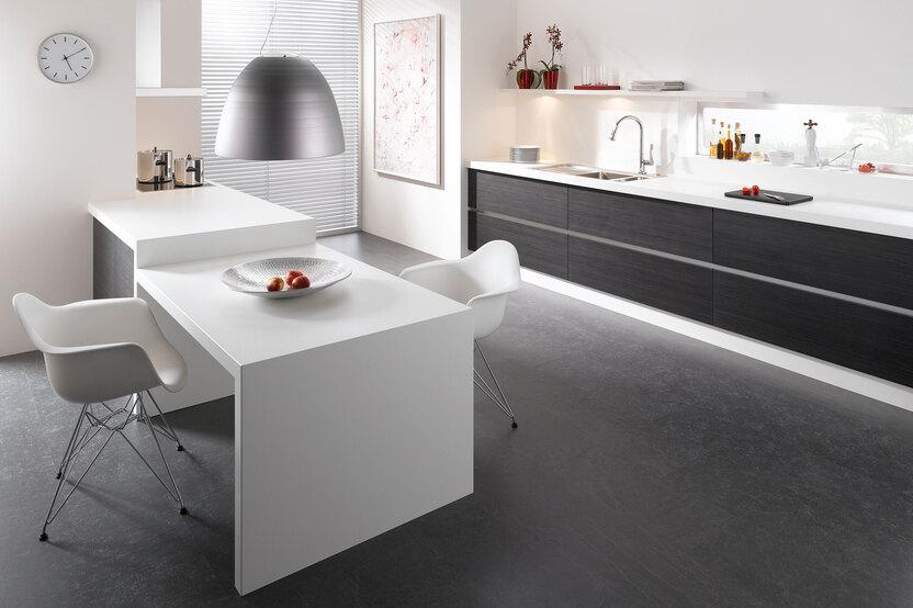 Impression einer Küchengestaltung mit Essplatz für Zwei Impression einer einzeiligen Küchengestaltung in schwarz-weiß mit Esstisch für Zwei
