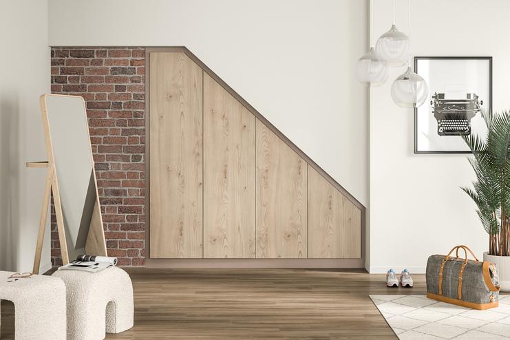 Maßgefertigter Wandschrank aus hellem Holz in einer stilvollen Diele Ein großer, eingebauter Wandschrank nach Maß mit hellen Holzfronten, integriert in eine Dachschräge neben einer Ziegelwand.