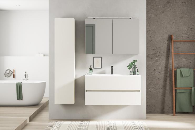 Minimalistisches Bad nach Maß mit klaren Linien Maßgefertigtes Bad mit schlichtem weißen Waschtisch, Spiegelschrank und betonfarbenen Wänden für einen modernen, puristischen Look.